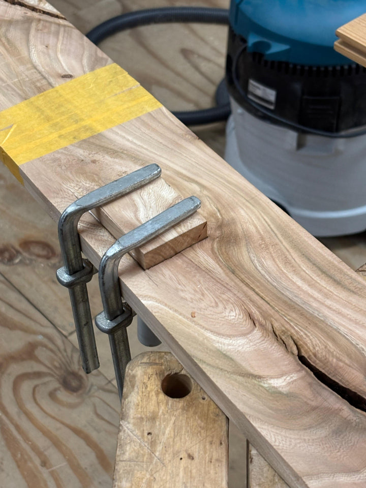 Tijdens de cursus hout kennis en reparatie wordt een nieuw stuk essen hout in een uitsparing gelijmd om het hout te repareren.
