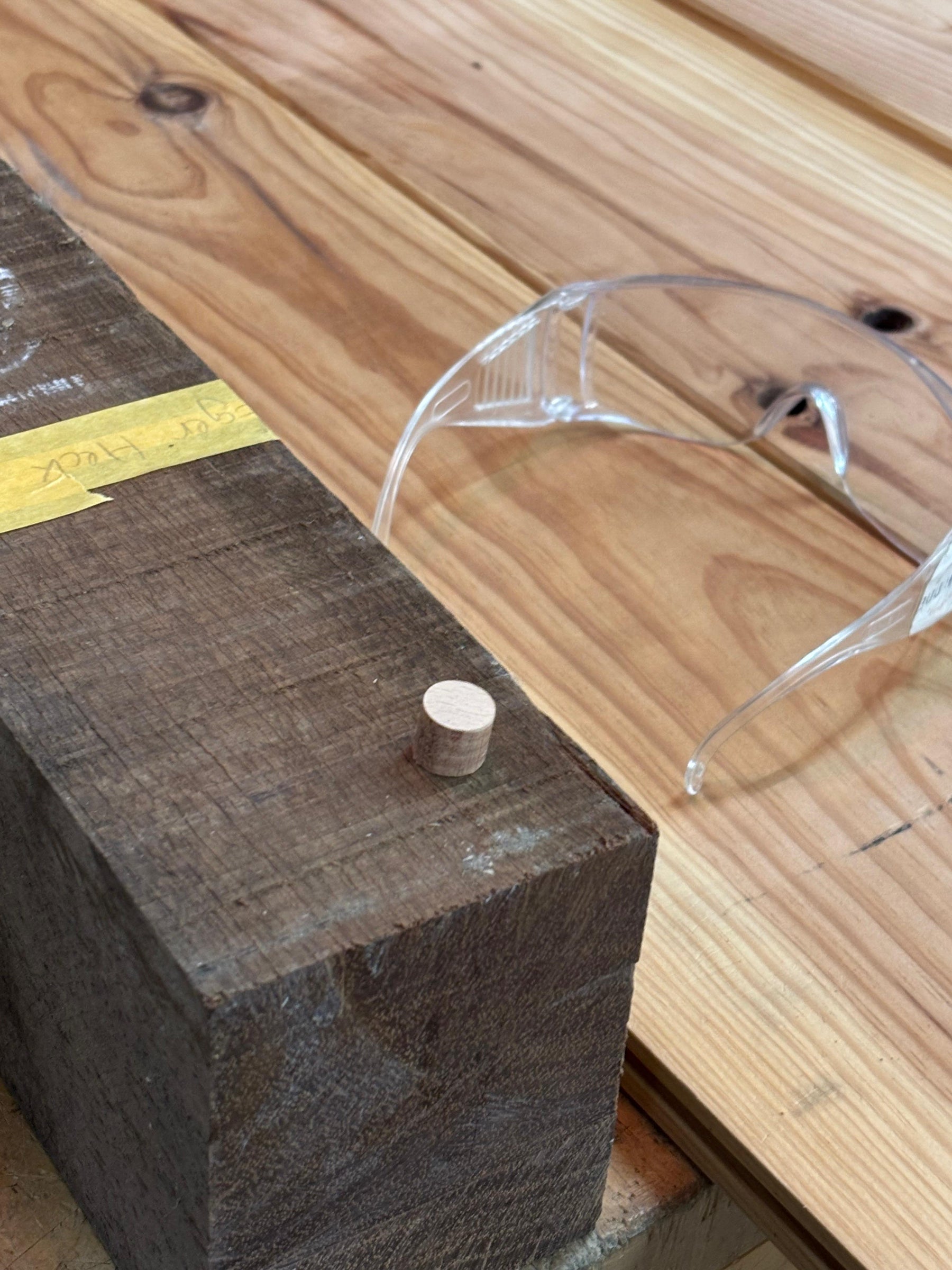 Tijdens de cursus hout kennis en reparatie, is in een donker stuk hardhout een gaatje gerepareerd door het te vullen met een licht stukje hout.
