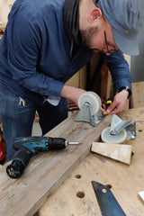 Teambuilding workshop zeepkistenstrijd bij Buurman Rotterdam. Meten waar de wielen moeten komen op de zeepkist.