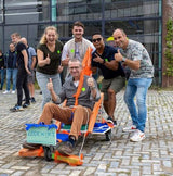 Teambuilding workshop zeepkistenstrijd bij Buurman Rotterdam, team poseert met hun eigen gemaakte zeepkist, klaar voor de race.