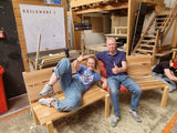 Deelnemers van de workshop bouw een bankje trots op hun eigen gemaakte tuin bankjes.