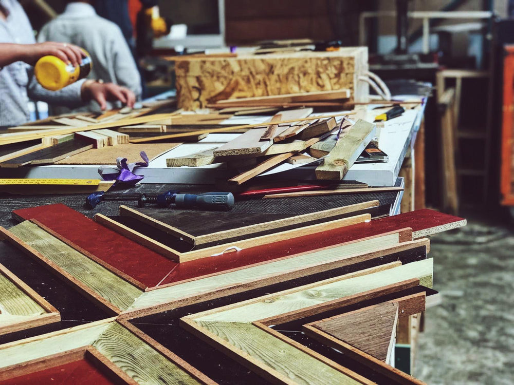 Er word een hout mozaïek gemaakt van verschillende kleuren hout. Het mozaïek wordt in een kruis patroon gelegd.