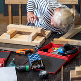 Een vrouw is tijdens de workshop Japans krukje het hout voor haar krukje aan het passen.