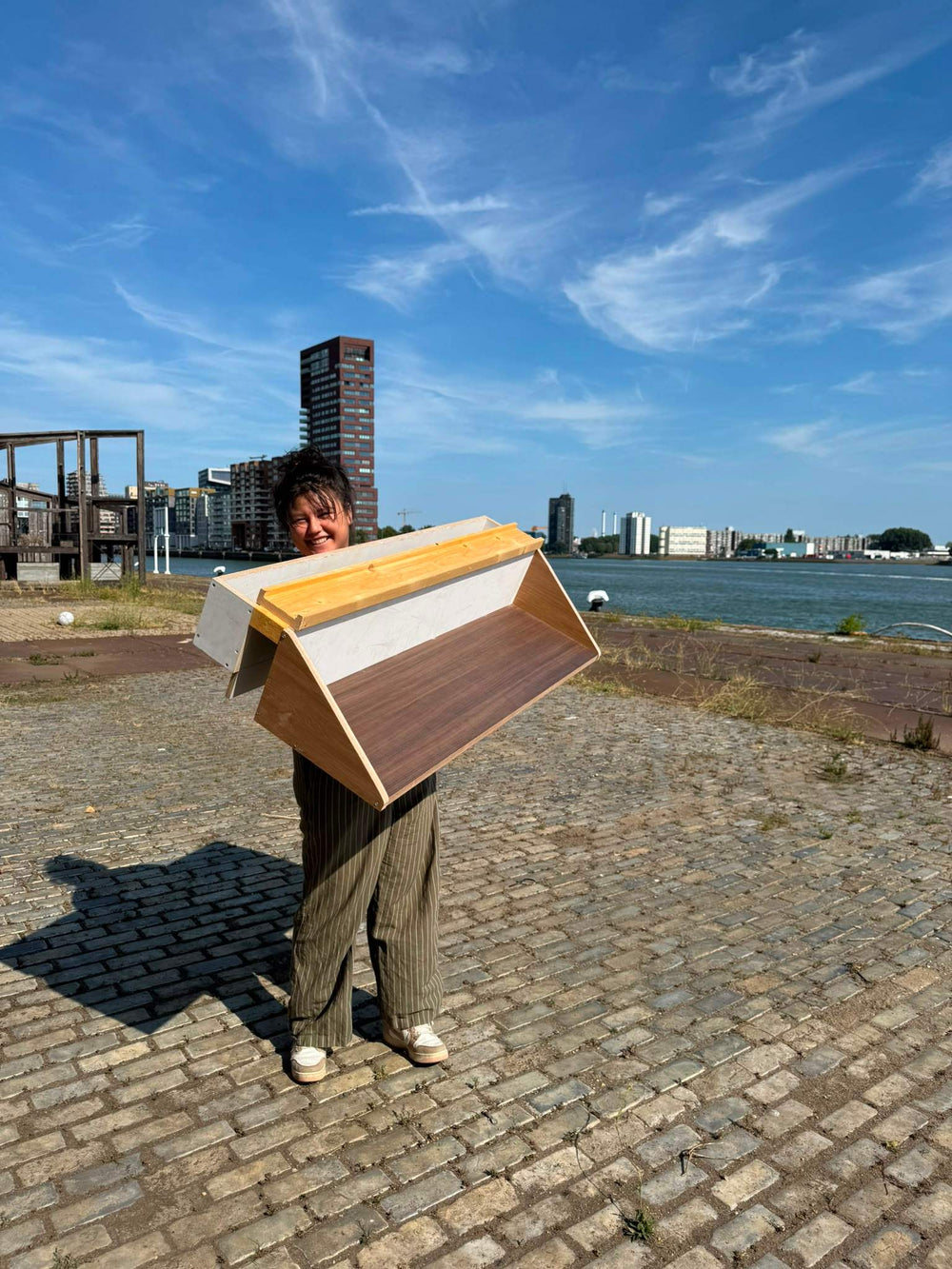 Een deelnemer van de workshop Bouw een Balkonbar, toont haar eigen gemaakte balkonbar met plantenbak.